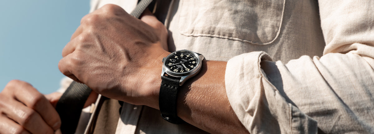DELMA Commander 40 mm stainless steel watch with black dial and black leather strap on wrist