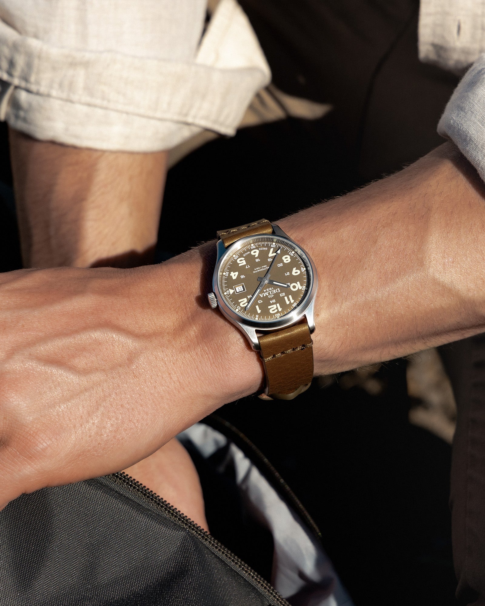 DELMA Commander 40 mm stainless steel watch with olive dial and olive leather strap on wrist