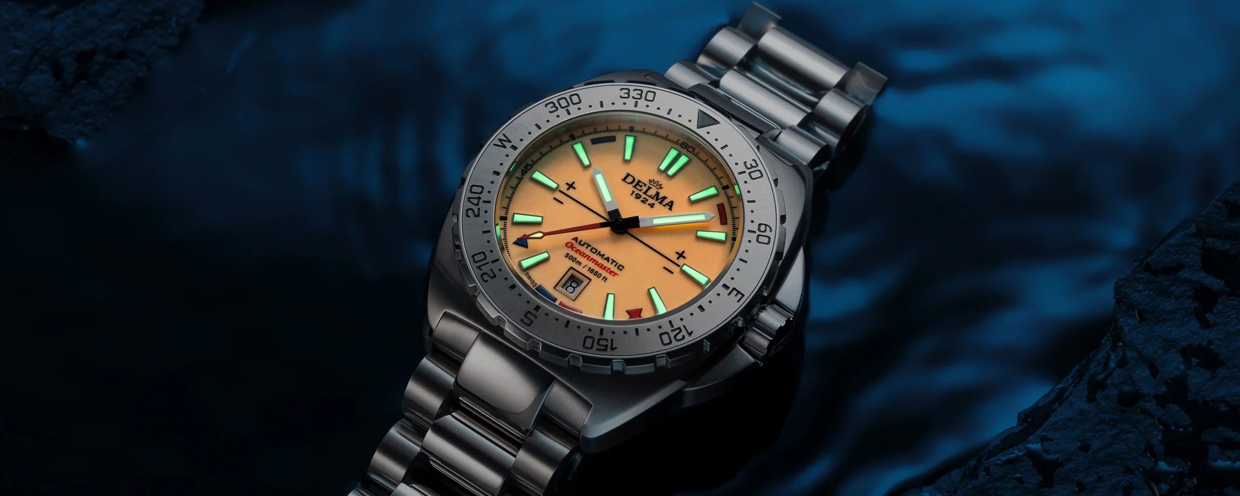 Delma Oceanmaster Lume orange dial stainless steel bracelet dark