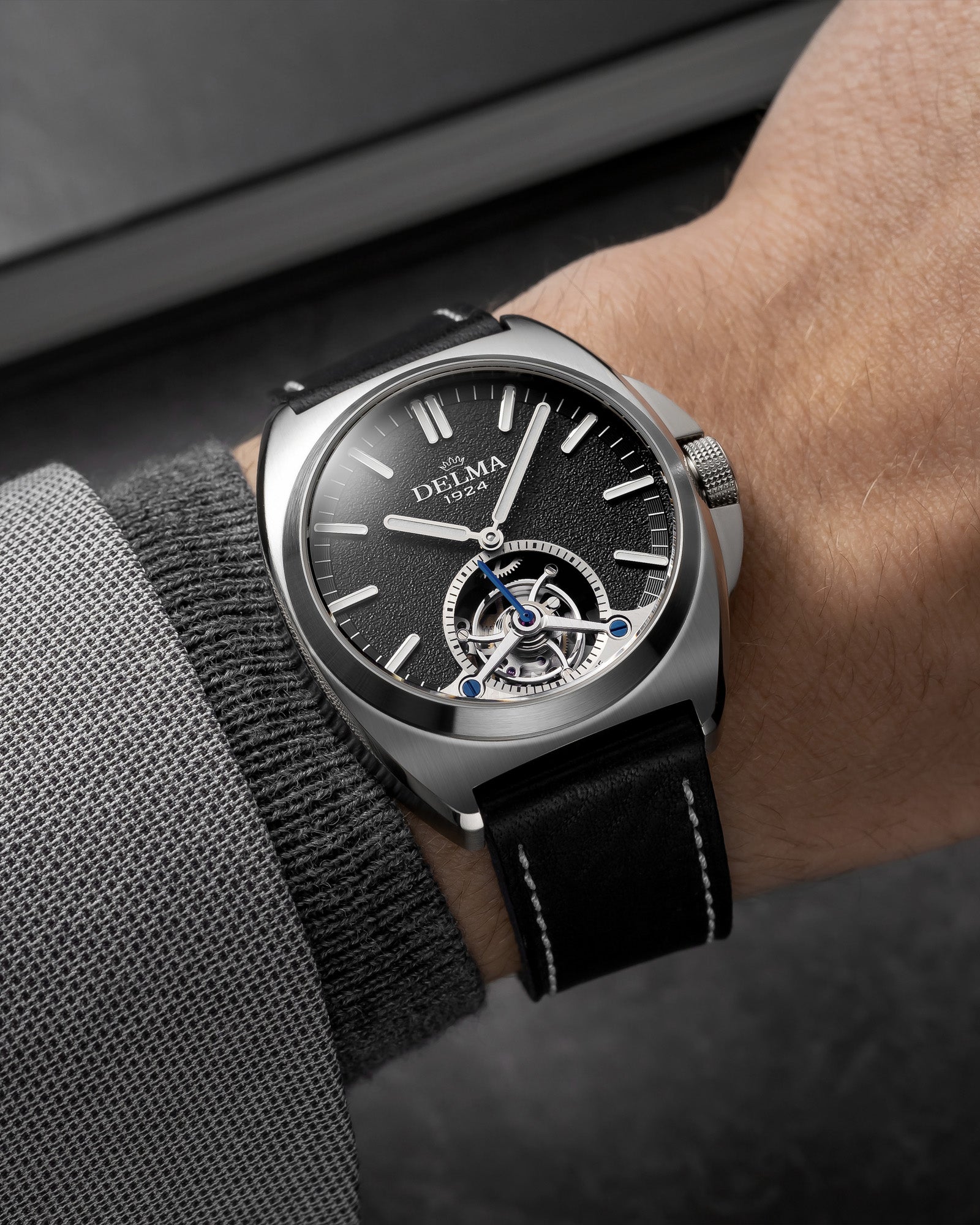 DELMA 1924 Tourbillon stainless steel watch with black dial and leather strap on wrist