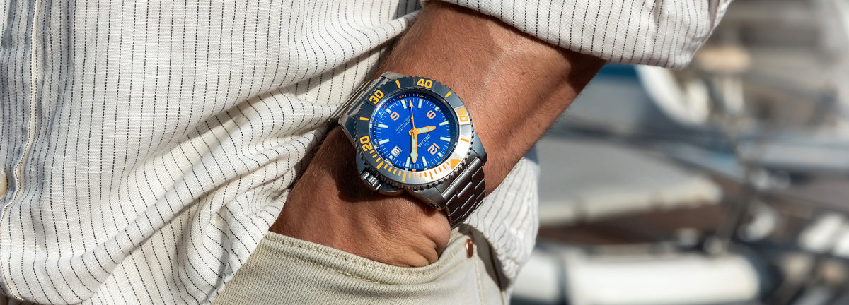 DELMA Blue Shark IV stainless steel watch with blue dial and black bezel on wrist