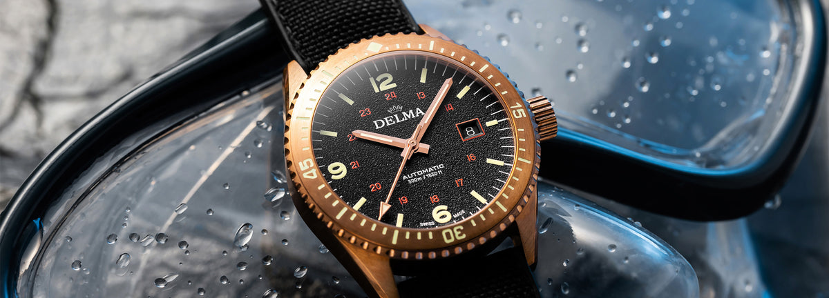 DELMA Cayman Bronze watch with black dial and black Cordura strap with dive mask
