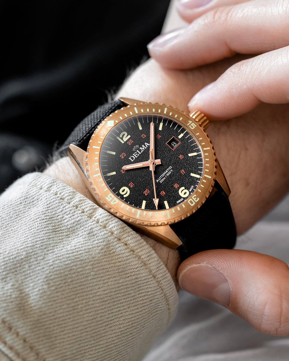 DELMA Cayman Bronze watch with black dial and black Cordura strap on wrist