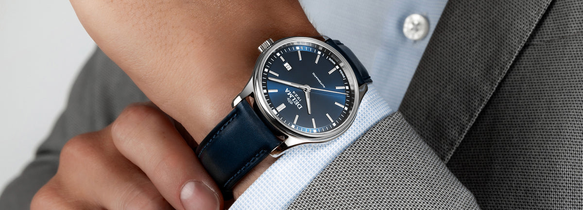 DELMA Classic stainless steel watch with blue dial and blue leather strap on wrist