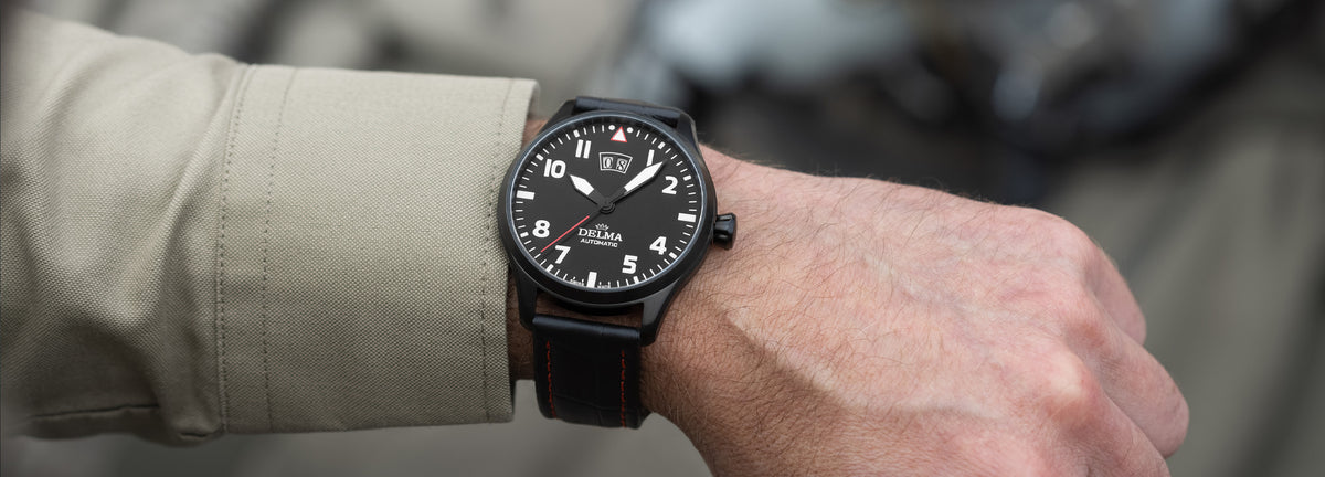 DELMA Commander Big Date stainless steel and black PVD watch with black dial and black leather strap on wrist