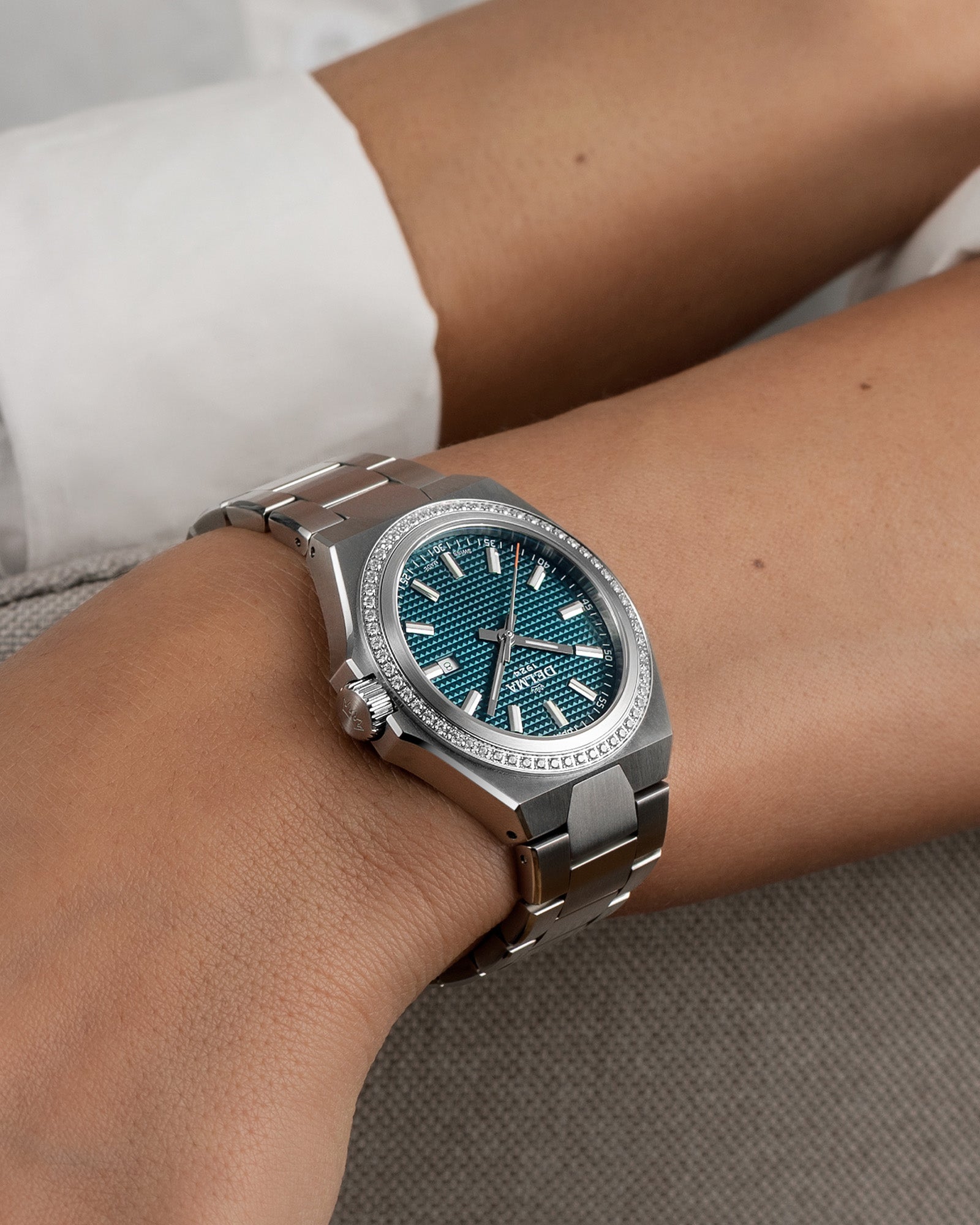 DELMA Midland 34 mm stainless steel watch with teal dial and diamond bezel on wrist