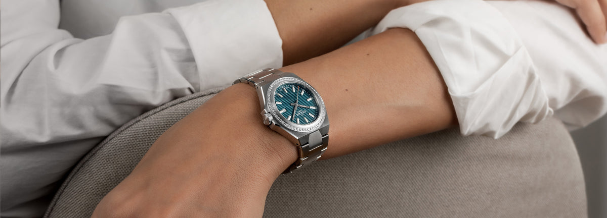 DELMA Midland 34 mm stainless steel watch with teal dial and diamond bezel on wrist