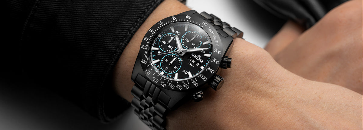 DELMA Montego Black Edition black DLC stainless steel watch with black dial and blue accents on wrist