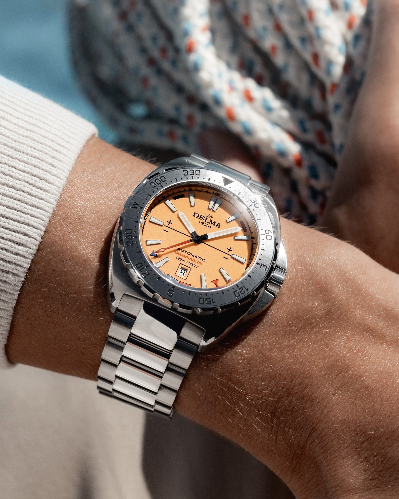 DELMA Oceanmaster Lume stainless steel watch with orange luminous dial wrist shot