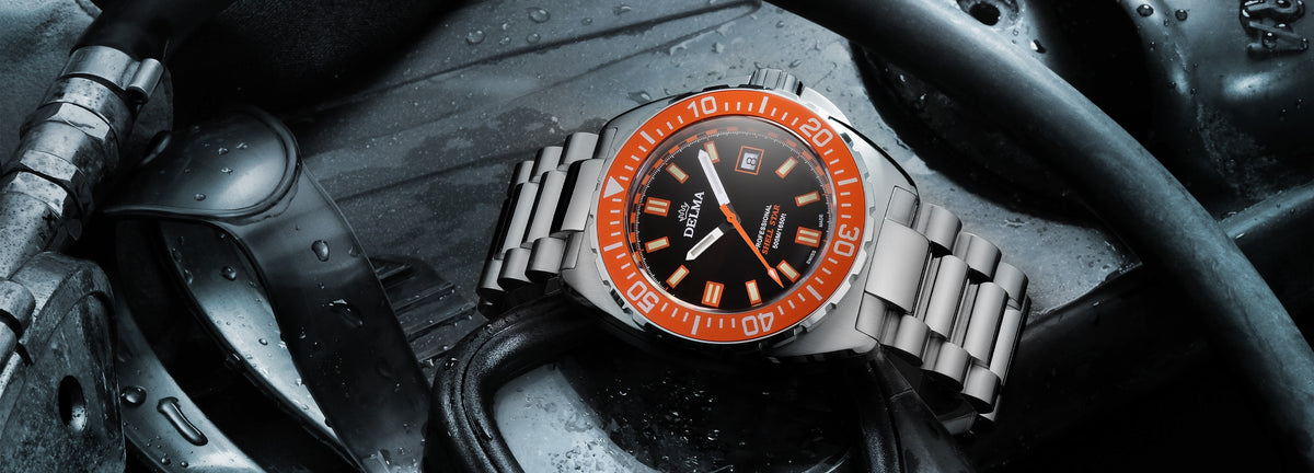 DELMA Shell Star stainless steel watch with black dial and orange bezel with dive gear