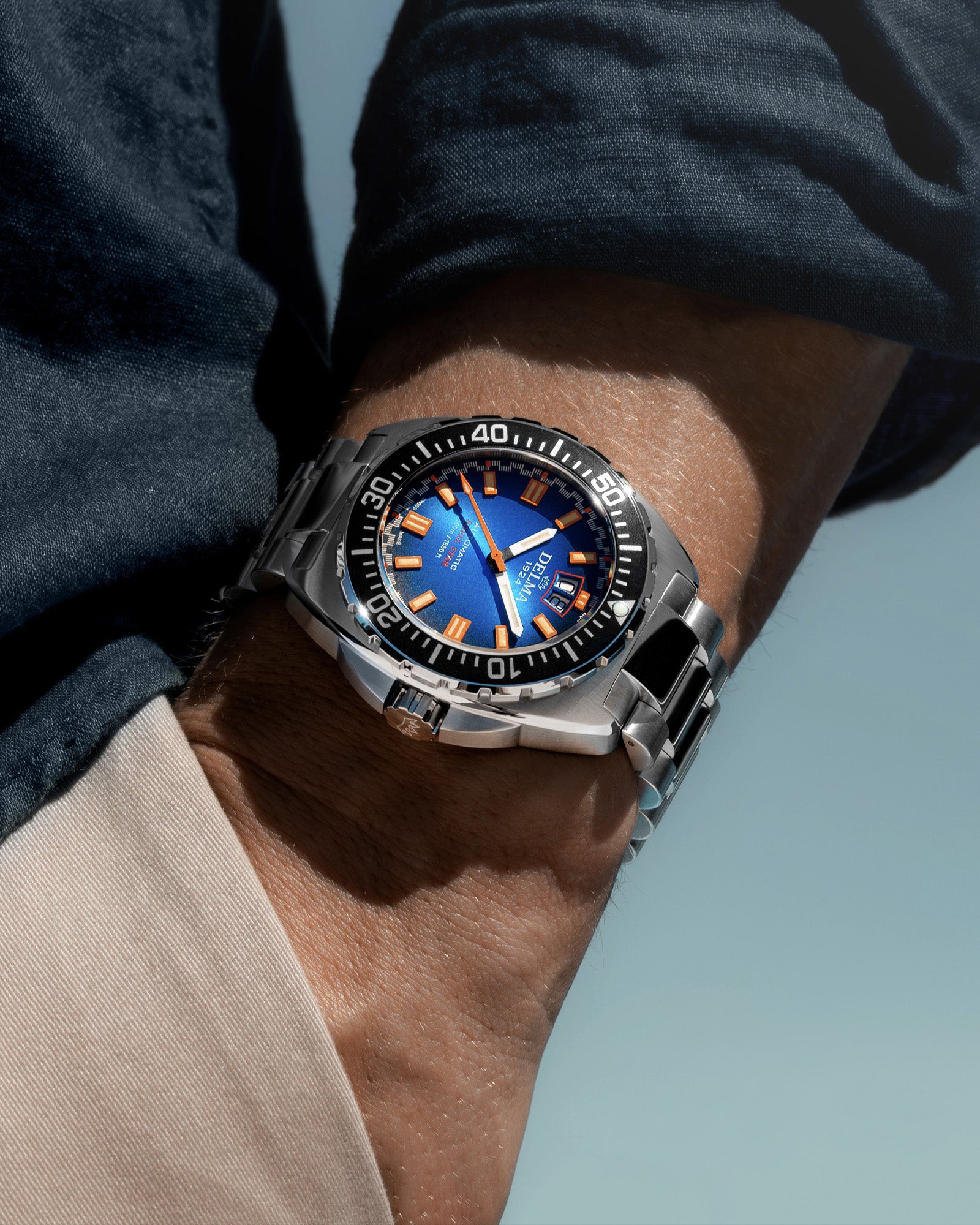 DELMA Shell Star Big Date stainless steel watch with blue dial and black bezel wrist shot