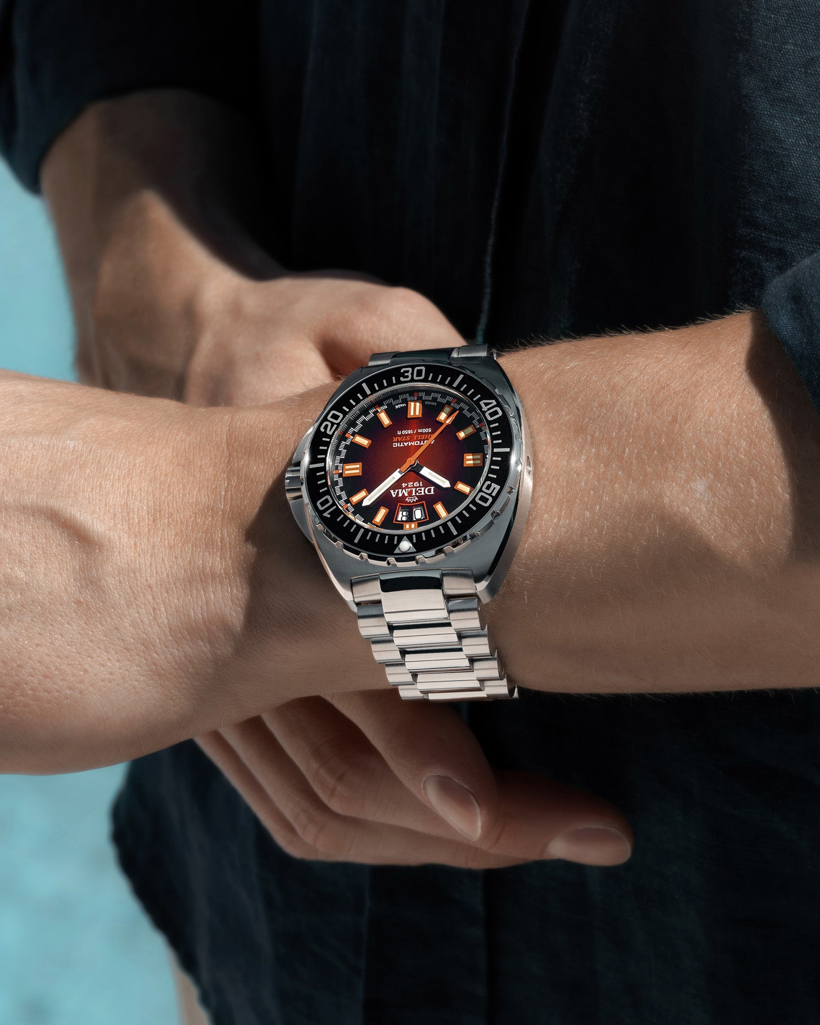 DELMA Shell Star Big Date stainless steel watch with brown dial and black bezel wrist shot