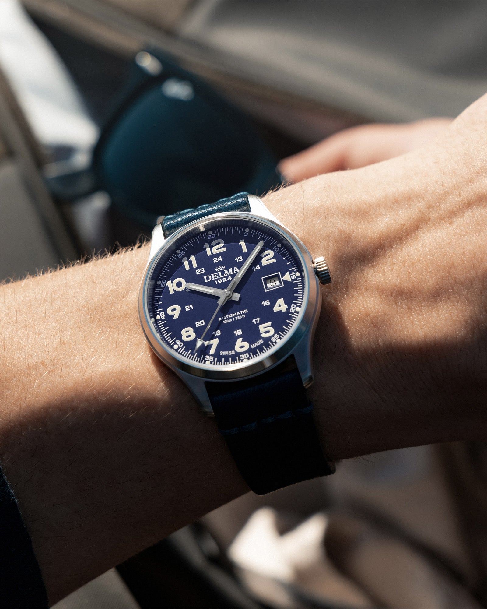 DELMA Commander 40 mm stainless steel watch with blue dial and blue leather strap on wrist