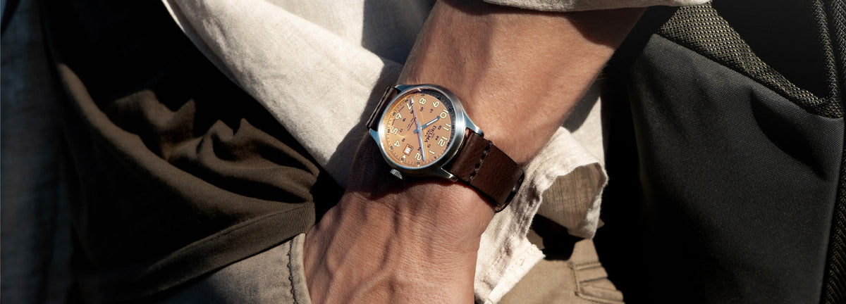 DELMA Commander 40 mm stainless steel watch with salmon dial and brown leather strap on wrist