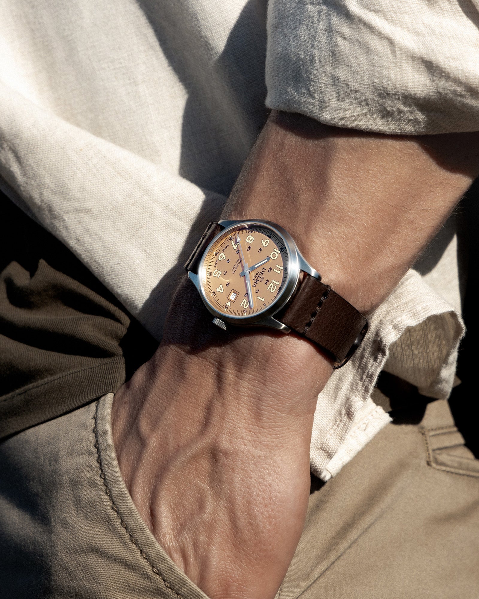 DELMA Commander 40 mm stainless steel watch with salmon dial and brown leather strap on wrist