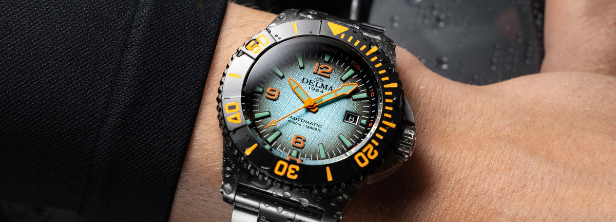DELMA Blue Shark IV stainless steel watch with blue gradient dial and black bezel on wrist