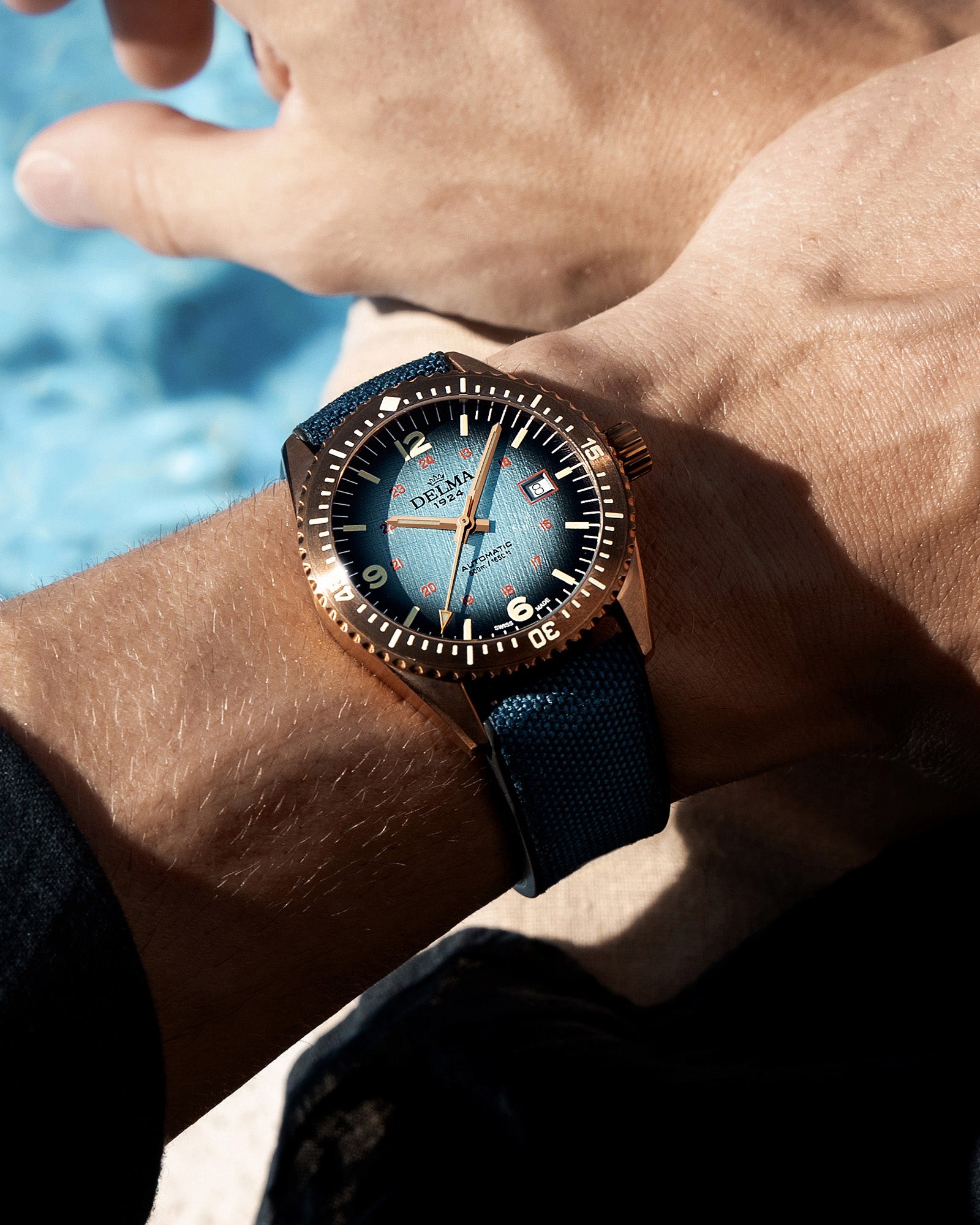 DELMA Cayman Bronze watch with blue gradient dial and blue Cordura strap wrist shot