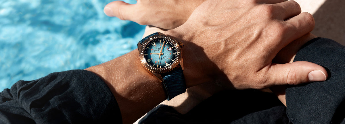 DELMA Cayman Bronze watch with blue gradient dial and blue Cordura strap on wrist