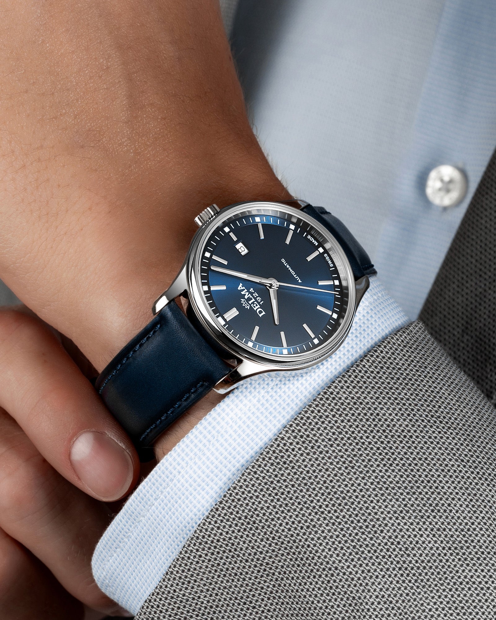 DELMA Classic stainless steel watch with blue dial and blue leather strap on wrist