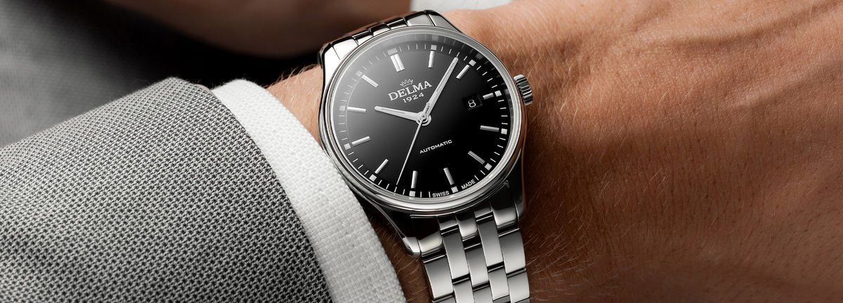 DELMA Classic stainless steel watch with black dial on wrist