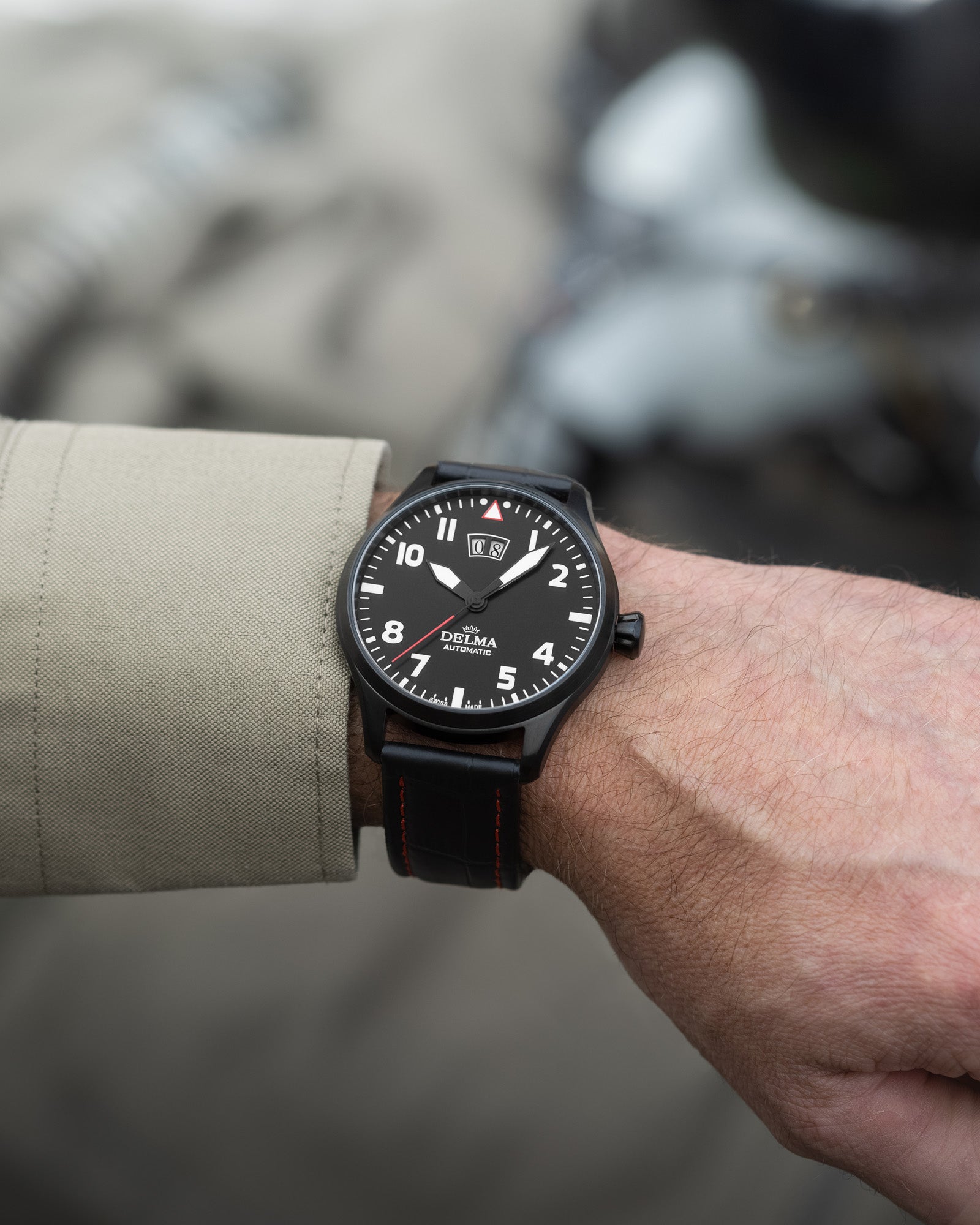 DELMA Commander Big Date stainless steel and black PVD watch with black dial and black leather strap on wrist