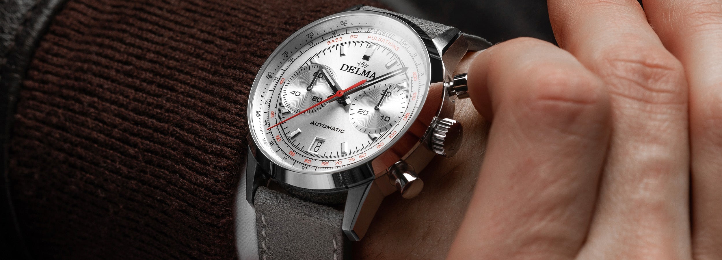 DELMA Continental Pulsometer stainless steel watch with silver dial and grey leather strap on wrist