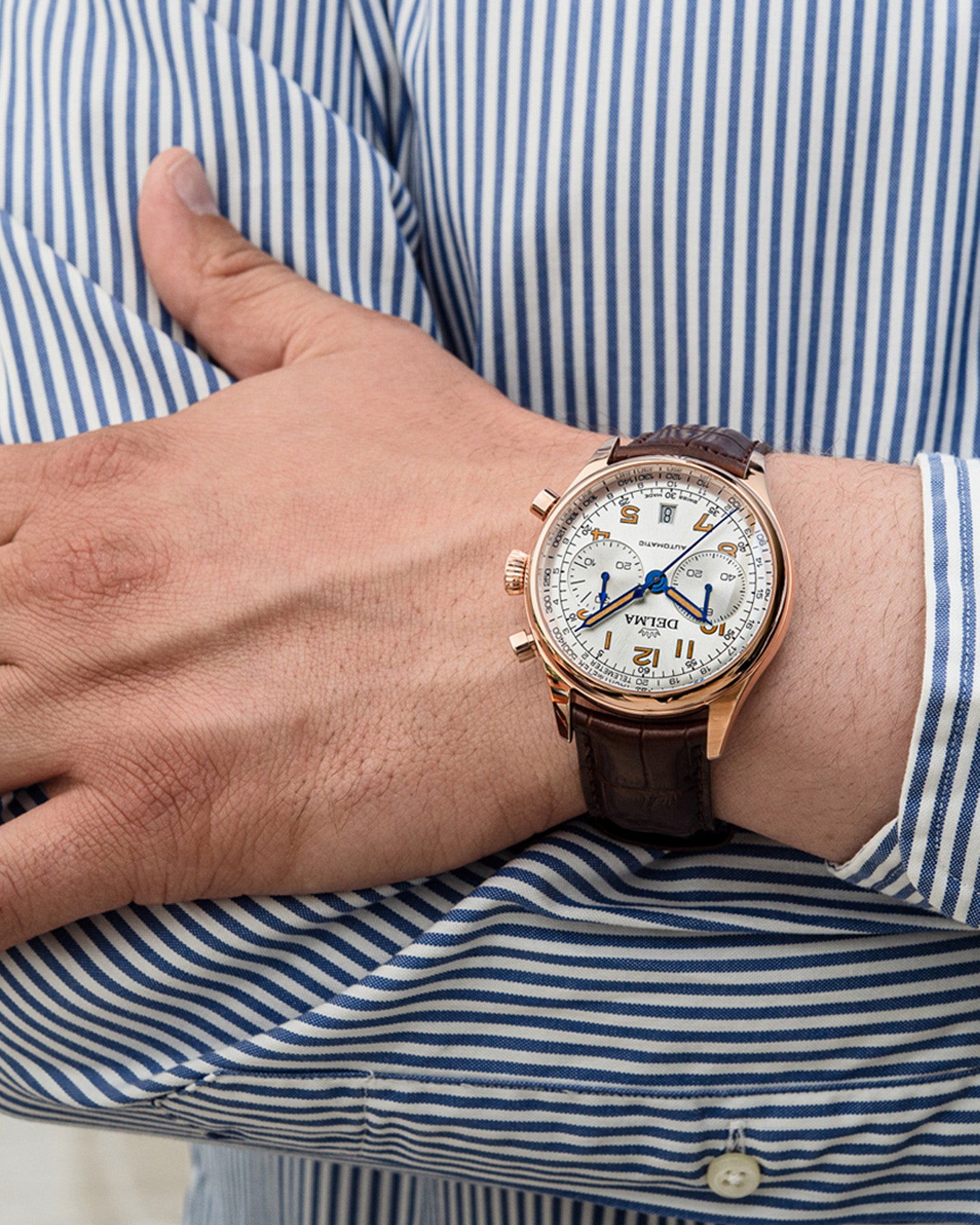 DELMA Heritage Chronograph LE stainless steel and rose gold PVD watch with silver dial and brown leather strap on wrist