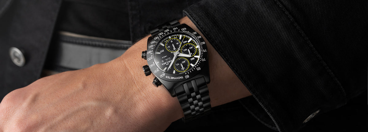 DELMA Montego Black Edition black DLC stainless steel watch with black dial and yellow accents on wrist