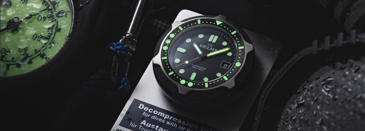 DELMA Quattro stainless steel watch with black dial and black bezel on decompression plate 