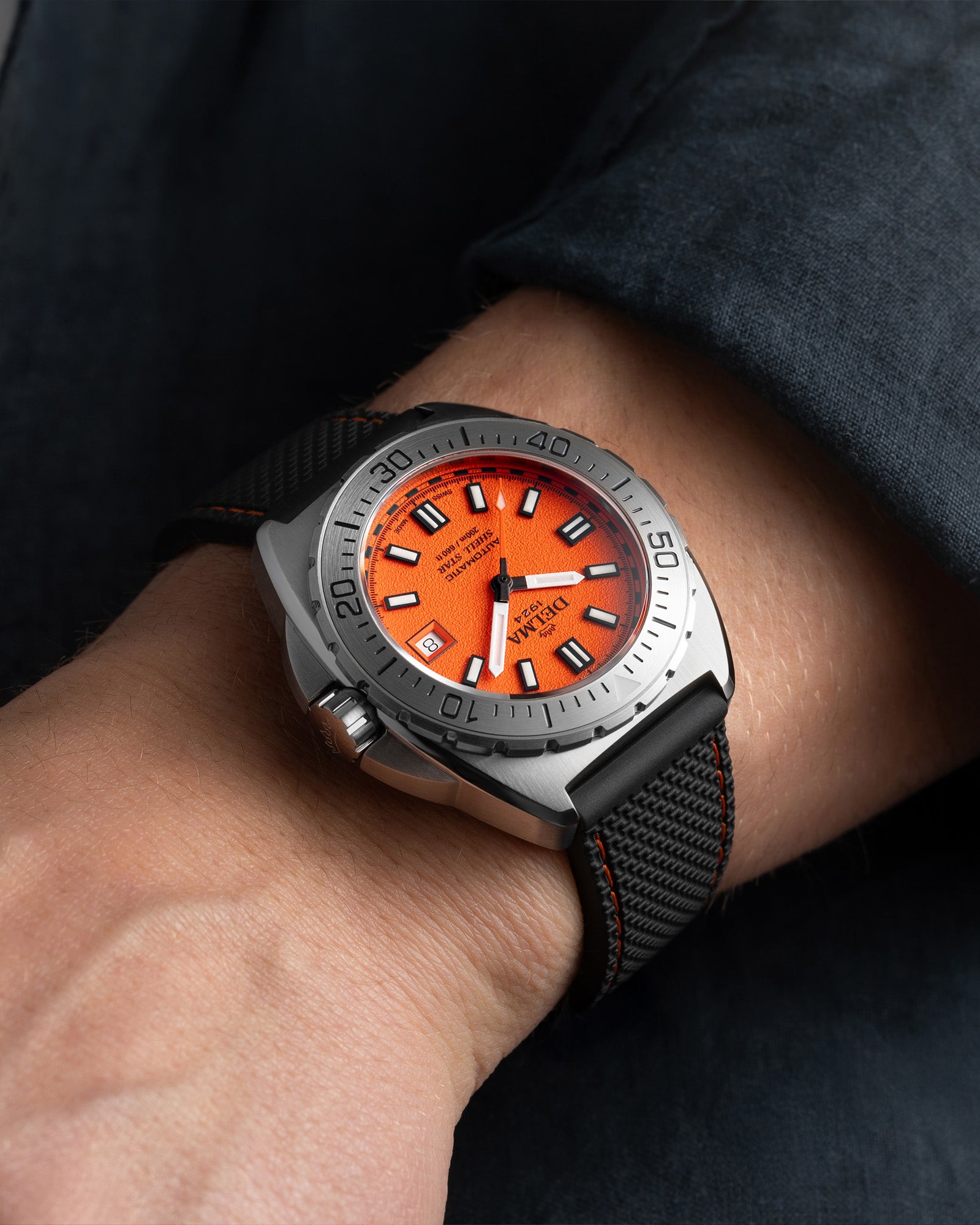 DELMA Shell Star 41 mm Automatic stainless steel watch with orange dial and black rubber strap wrist shot