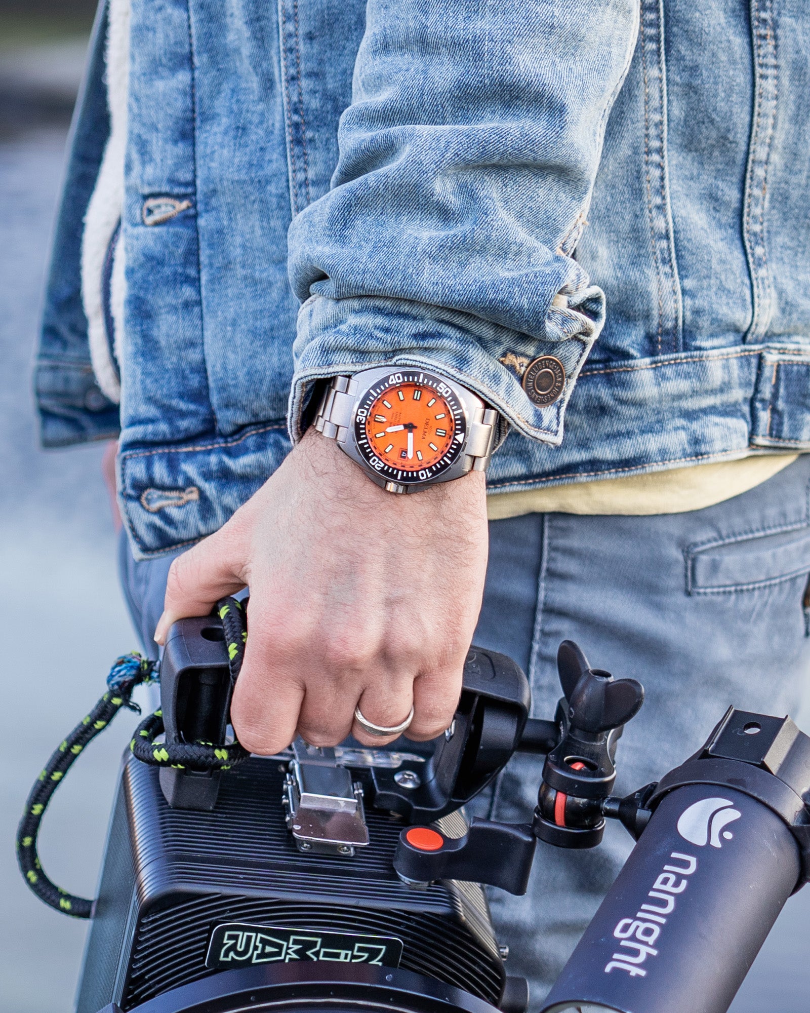 DELMA Shell Star Titanium stainless steel watch with orange dial and black bezel wrist shot