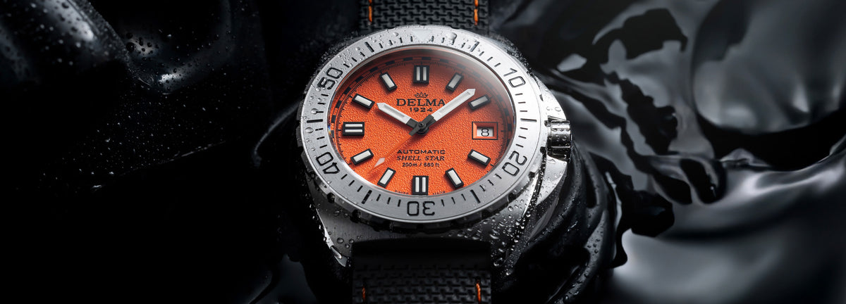 DELMA Shell Star 41 mm stainless steel watch with orange dial and black rubber strap in water